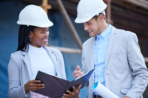 two construction professionals discussing plans with hard hats on 7 project management strategies