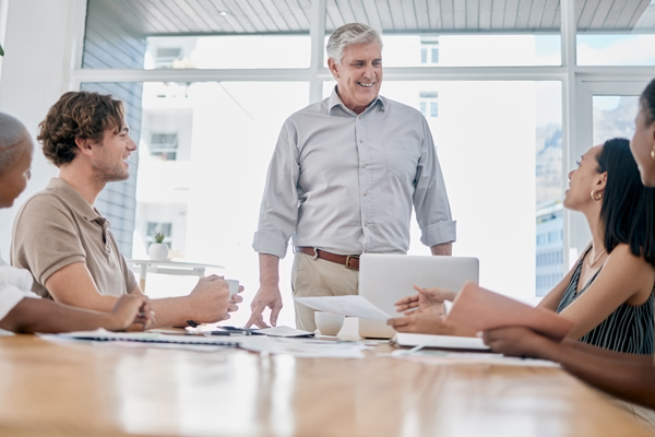 business meeting with diverse group of professionals discussing strategies surrounding four key topics in a bright office setting