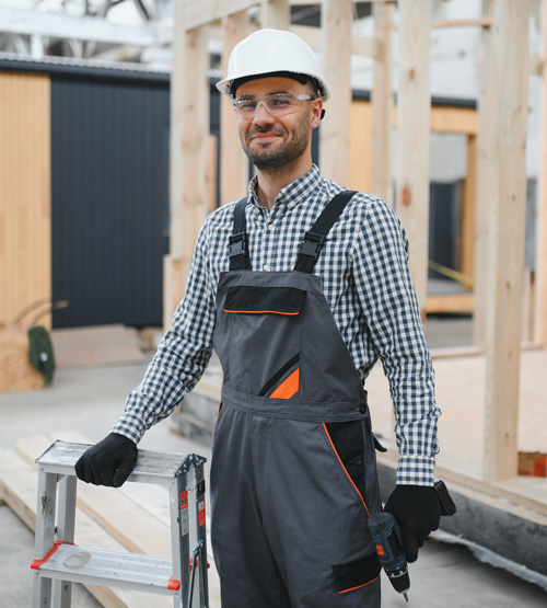 smiling construction worker in safety gear standing next to a ladder in a building site environment focusing on safety and quality five essential construction skills