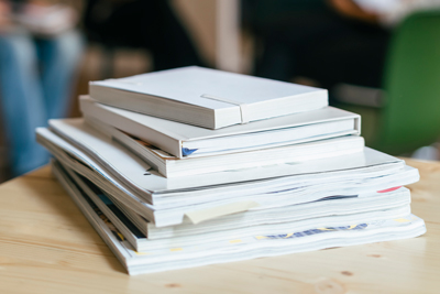 a stack of various books and magazines on a wooden table showcasing different covers and sizes ideal for studying and research 4 essential resources for students